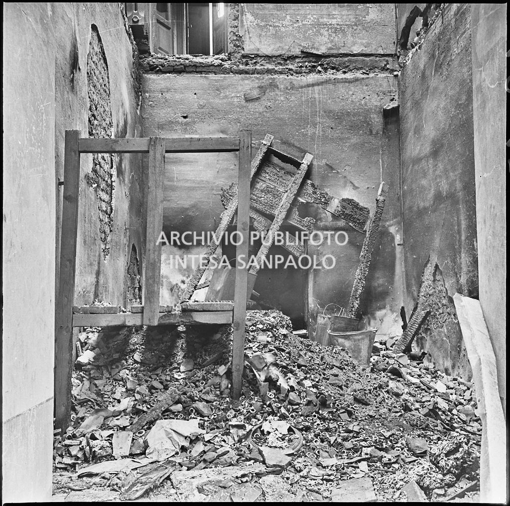 Macerie e pezzi di legno bruciati all'interno della ditta R. Romanelli, a Milano, che produceva copertoni e tendoni impermeabili, gravemente danneggiata dai bombardamenti