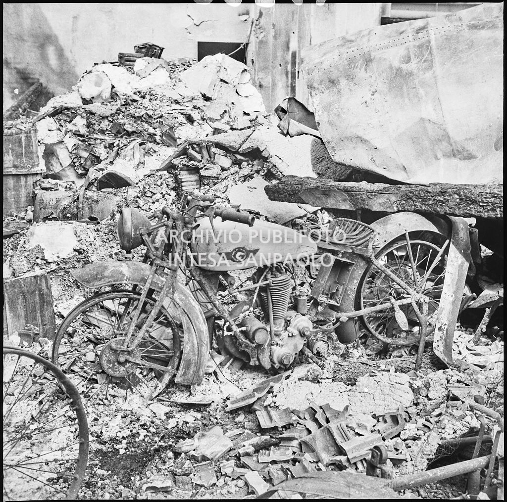Una motocicletta tra le macerie dei bombardamenti che hanno distrutto lo stabilimento italiano lavori in carta affini (SILICA), in corso di Porta Nuova a Milano