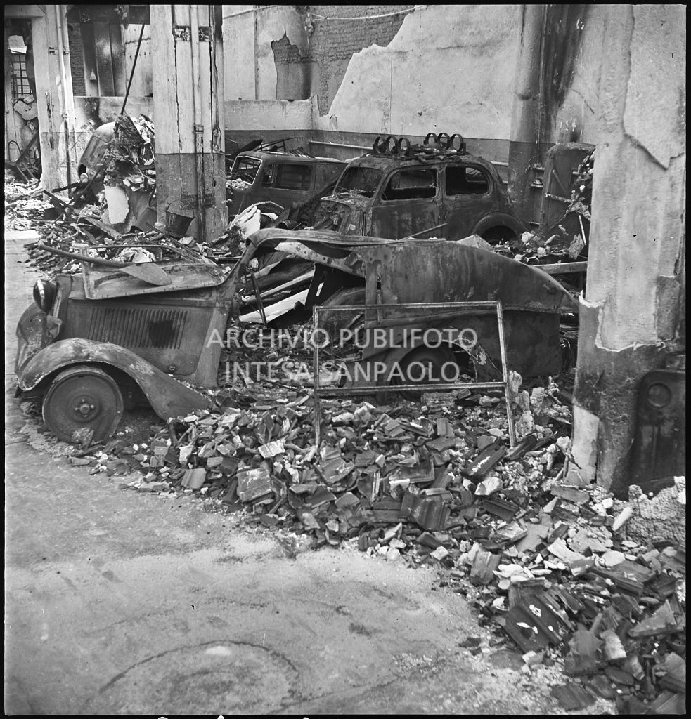 Interno di un'autorimessa colpita dai bombardamenti che hanno distrutto le automobili ricoverate