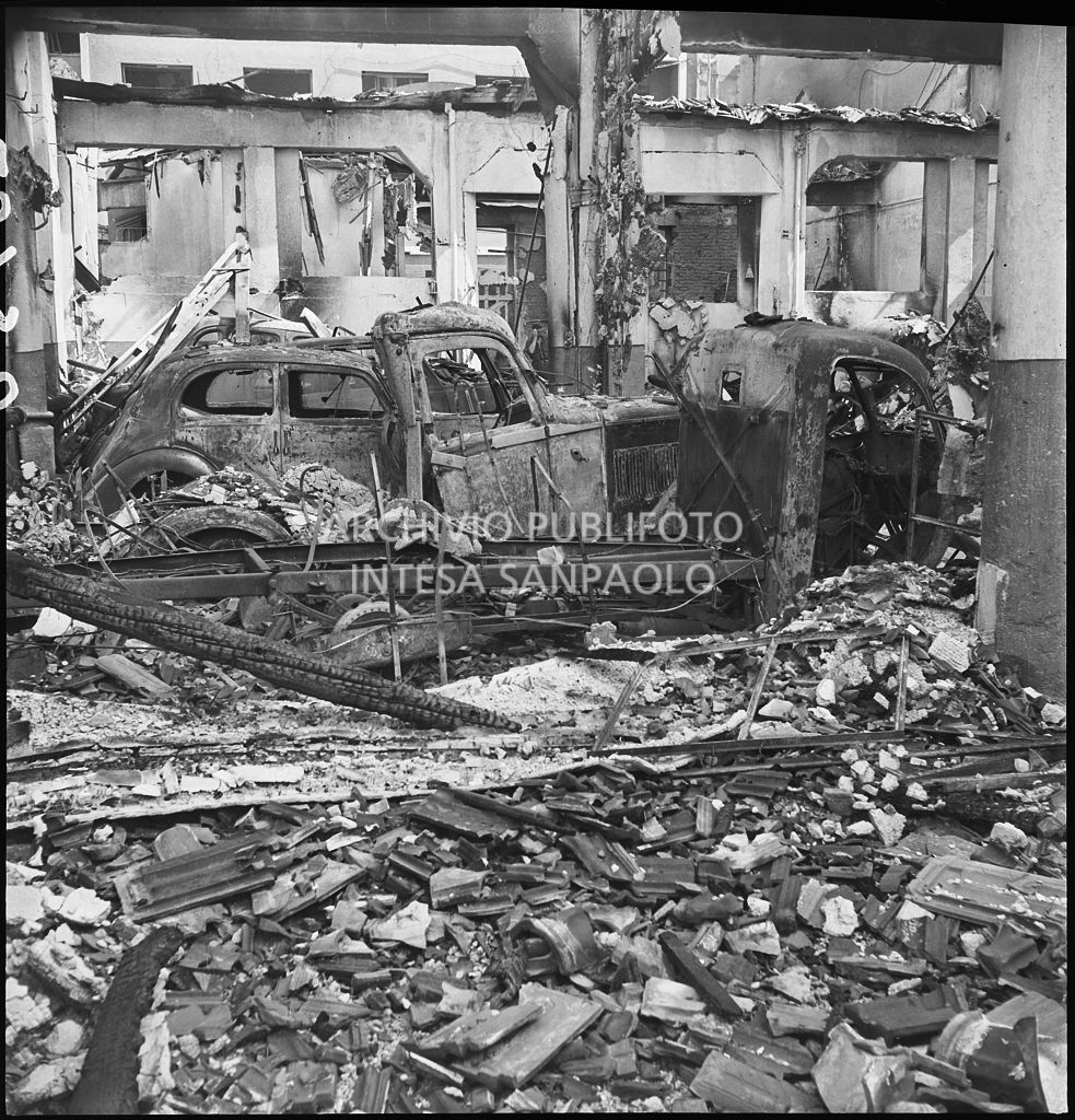 Interno di un'autorimessa colpita dai bombardamenti che hanno distrutto le automobili ricoverate