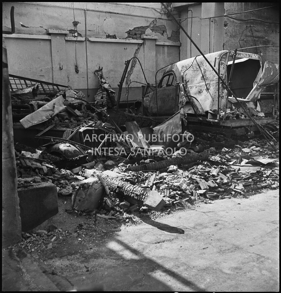 Interno di un'autorimessa colpita dai bombardamenti che hanno distrutto le automobili ricoverate
