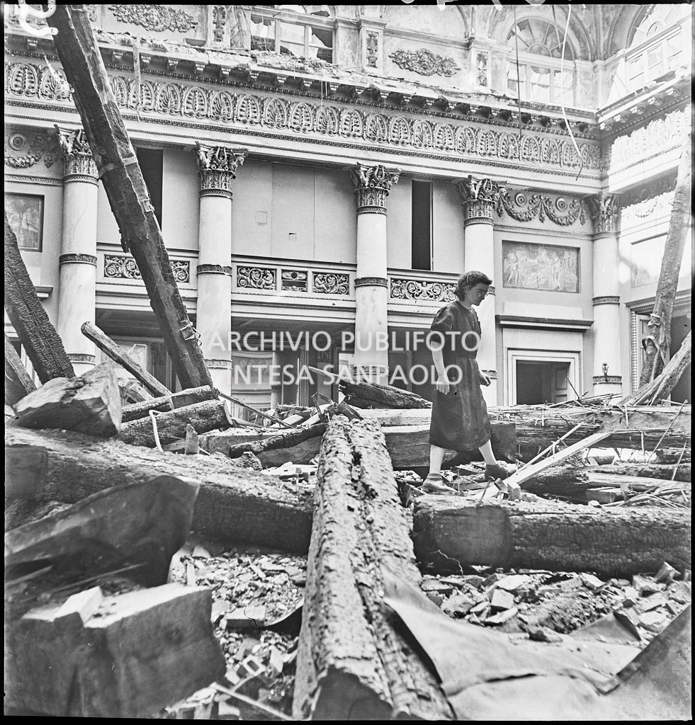 Una donna tra le macerie nella Sala d'oro di Palazzo Spinola, sede della Società del Giardino, in via San Paolo 10 a Milano, gravemente danneggiata dai bombardamenti
