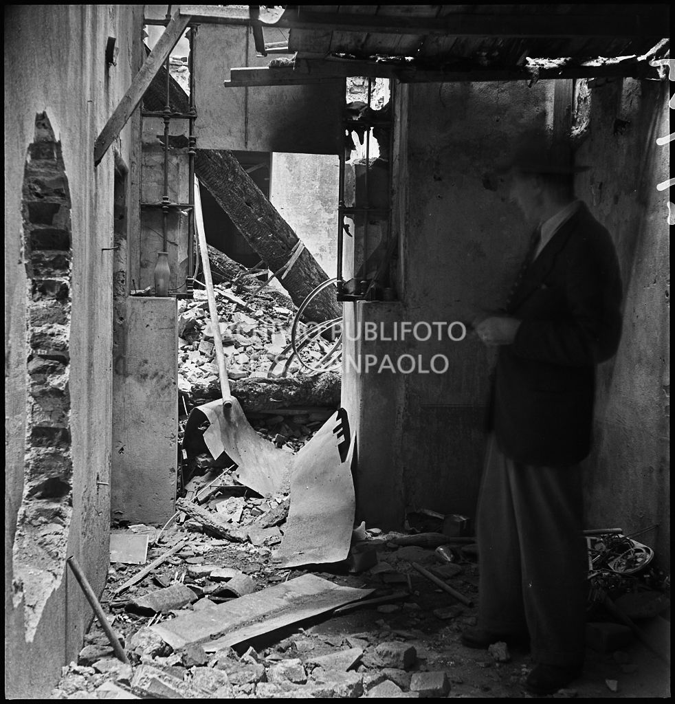 Un uomo osserva la devastazione causata dai bombardamenti presso la sede della impresa Sacchi e Savio, in via Solferino 40 a Milano, che era attiva nel settore delle biciclette e motociclette