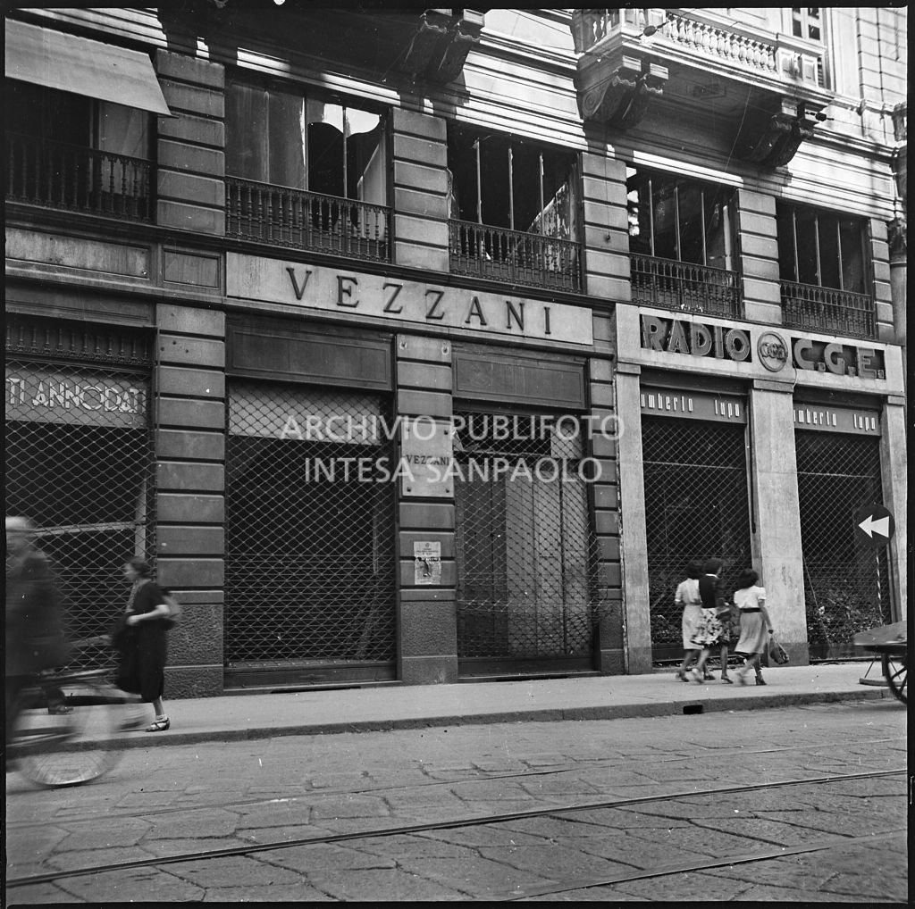 Esterno della camiceria Vezzani, in via Dante a Milano, dopo i bombardamenti; a destra il negozio di Umberto Lupo Radio CGE al cui interno si distinguono le macerie