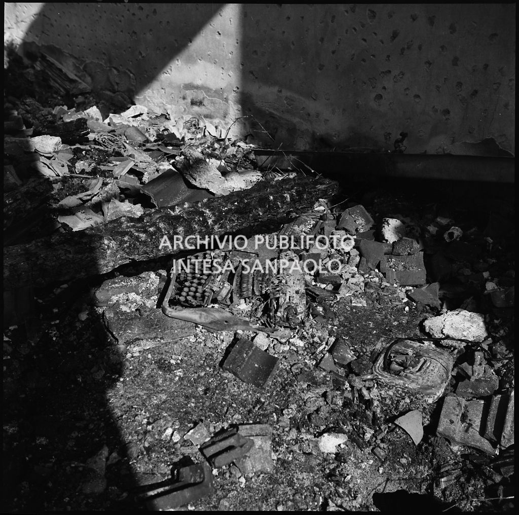 Macerie all'interno di un appartamento, a Milano, gravemente danneggiato dai bombardamenti; a terra una macchina da scrivere