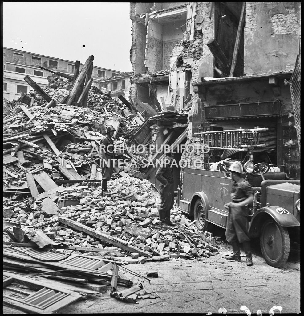Un militare  e due vigili del fuoco tra le macerie degli edifici di via Alciato, a Milano, distrutti dai bombardamenti