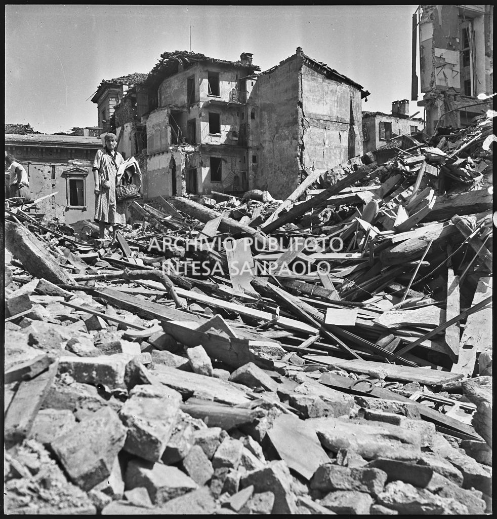 Una donna osserva le macerie degli edifici di via Alciato, a Milano, distrutti dai bombardamenti