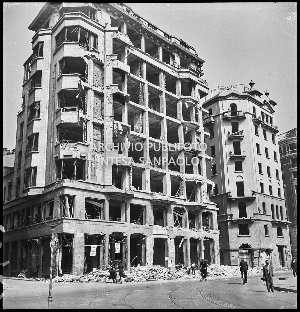 Edificio in largo Augusto, tra via Cerva e via Marziale, a Milano, sventrato dai bombardamenti; alcuni passanti per strada