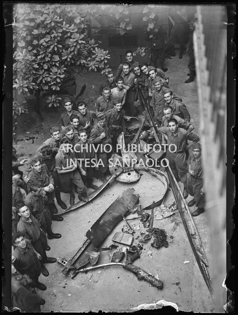 Foto di gruppo di militari in posa intorno ai rottami di un aereo abbattuto