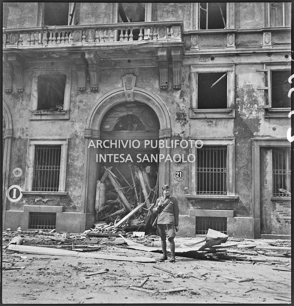 Un militare staziona tra le macerie davanti all'ingresso del palazzo in via Brera 21, a Milano, devastato dai bombardamenti