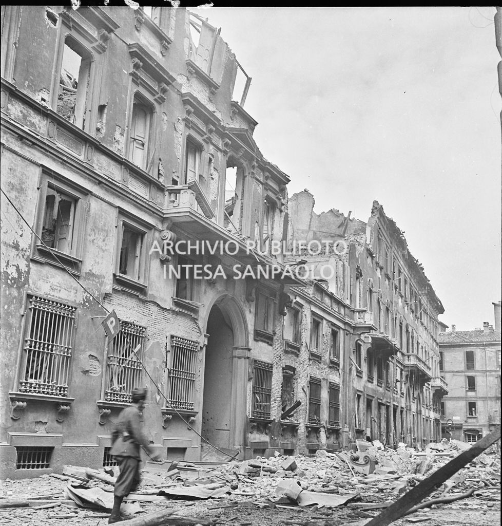 Un uomo cammina in via Brera, a Milano, tra le macerie dei palazzi bombardati