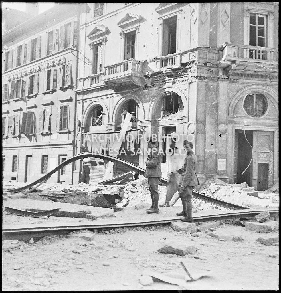 Militari in piazza Cavour a Milano tra le macerie degli edifici bombardati e i binari del tram divelti