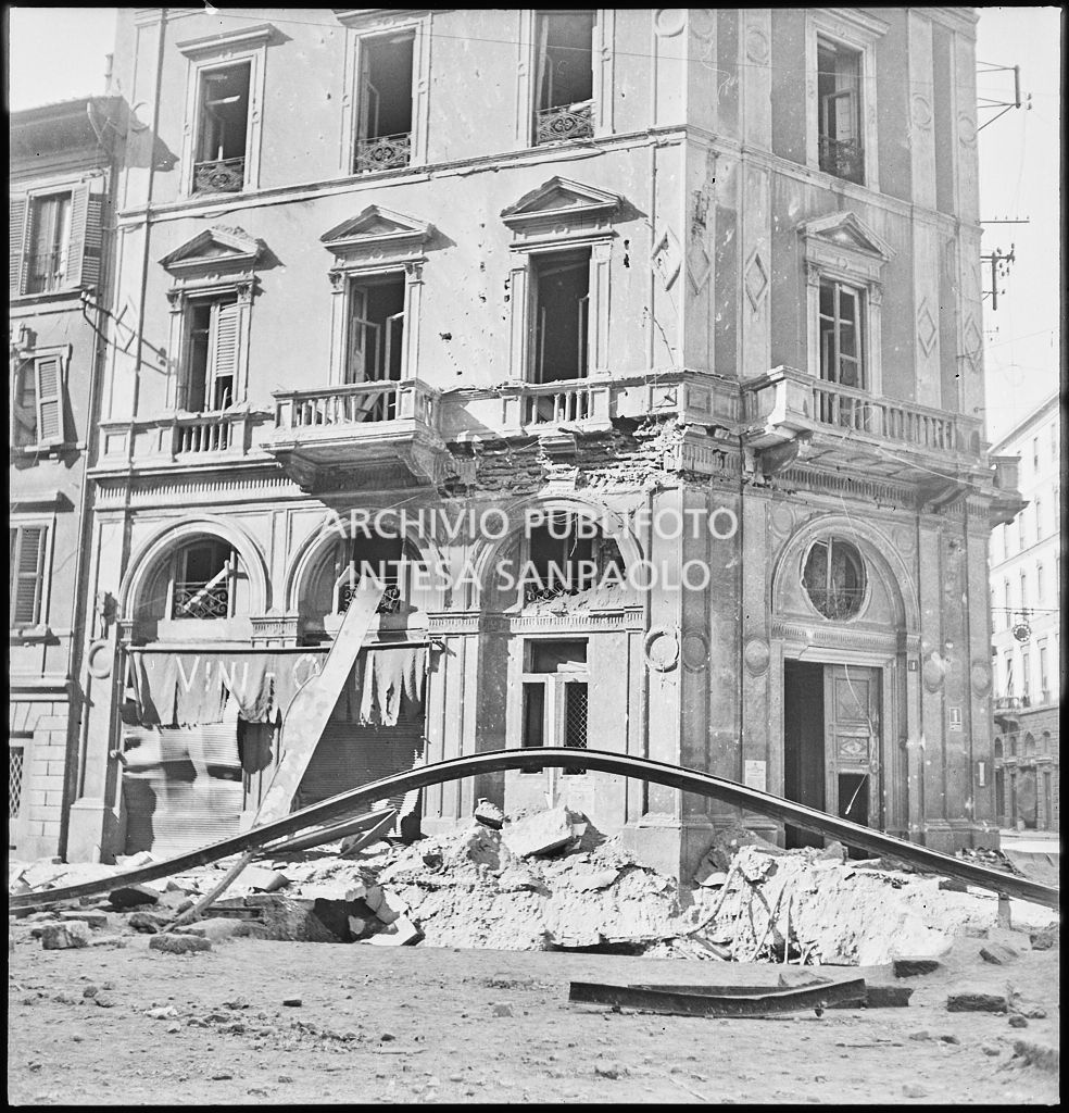 Binari dei tram divelti dai bombardamenti in piazza Cavour a Milano; sullo sfondo l'edificio all'angolo con via Fatebenefratelli gravemente danneggiato