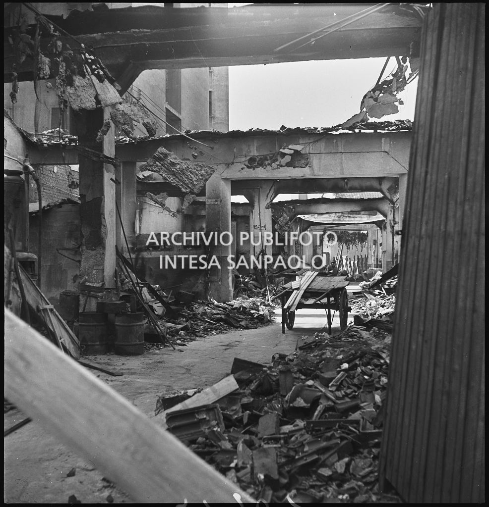 Interno di un edificio sventrato dai bombardamenti in viale Coni Zugna a Milano; al centro un carro, ai lati macerie ammassate