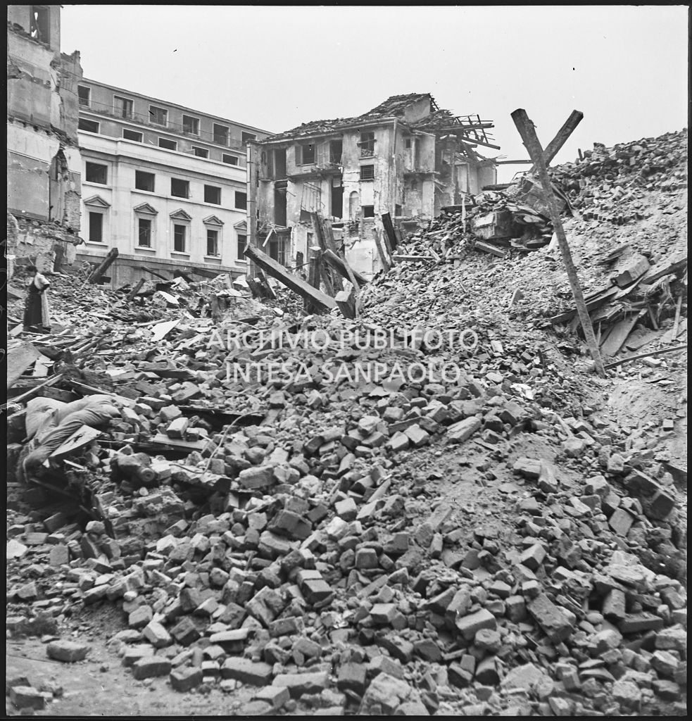 Macerie degli edifici tra via San Sisto, largo Carrobbio e via Medici, a Milano, bombardati; a sinistra una donna
