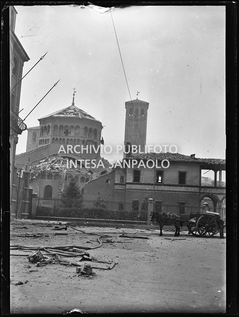 Esterno della basilica di Sant'Ambrogio a Milano danneggiata dai bombardamenti. Sulla destra un cavallo con carro a traino