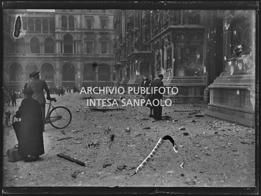 Passanti, sul sagrato del Duomo di Milano, tra i detriti dei bombardamenti