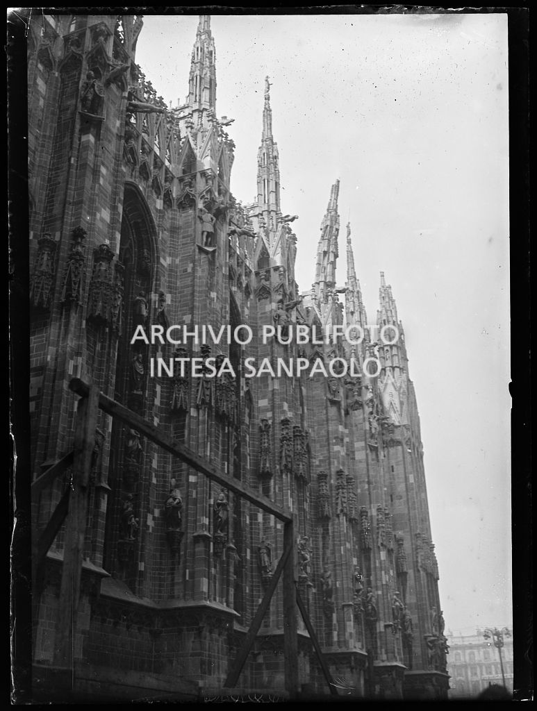 Vista dal basso del lato nord del Duomo di Milano con una guglia danneggiata dai bombardamenti e pericolante
