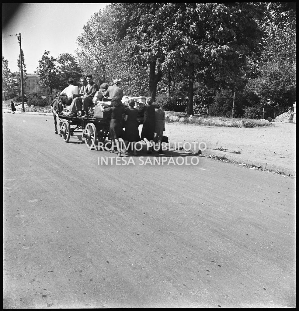 Esodo dalla città, dopo i bombardamenti di Milano, con un carro trainato da un cavallo, ai Bastioni di Porta Venezia: le donne a piedi, gli uomini a bordo