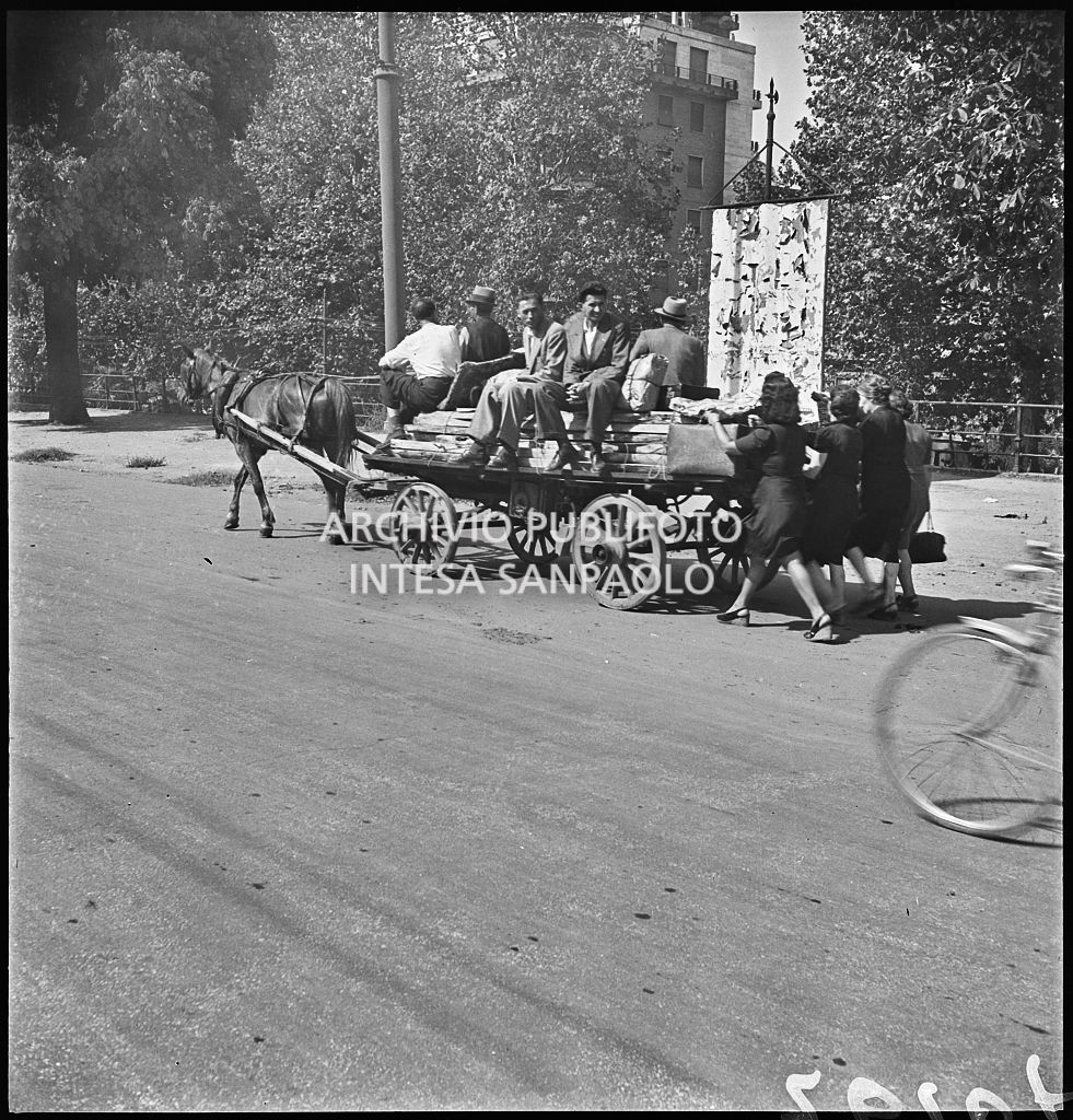Esodo dalla città, dopo i bombardamenti di Milano, con un carro trainato da un cavallo ai Bastioni di Porta Venezia: le donne a piedi, gli uomini a bordo