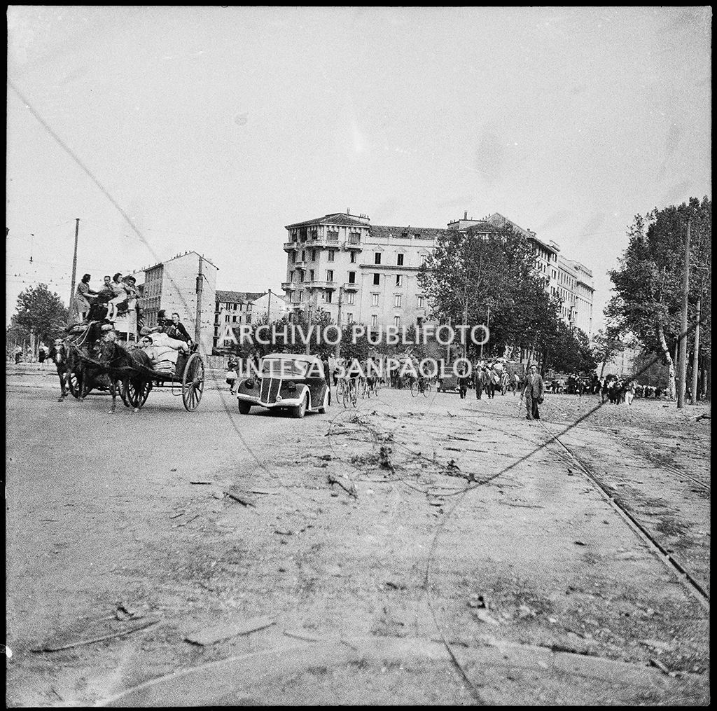 Esodo dei milanesi, dopo i bombardamenti della città, con carri, trainati da cavalli, carichi di masserizie, in bicicletta o in automobile