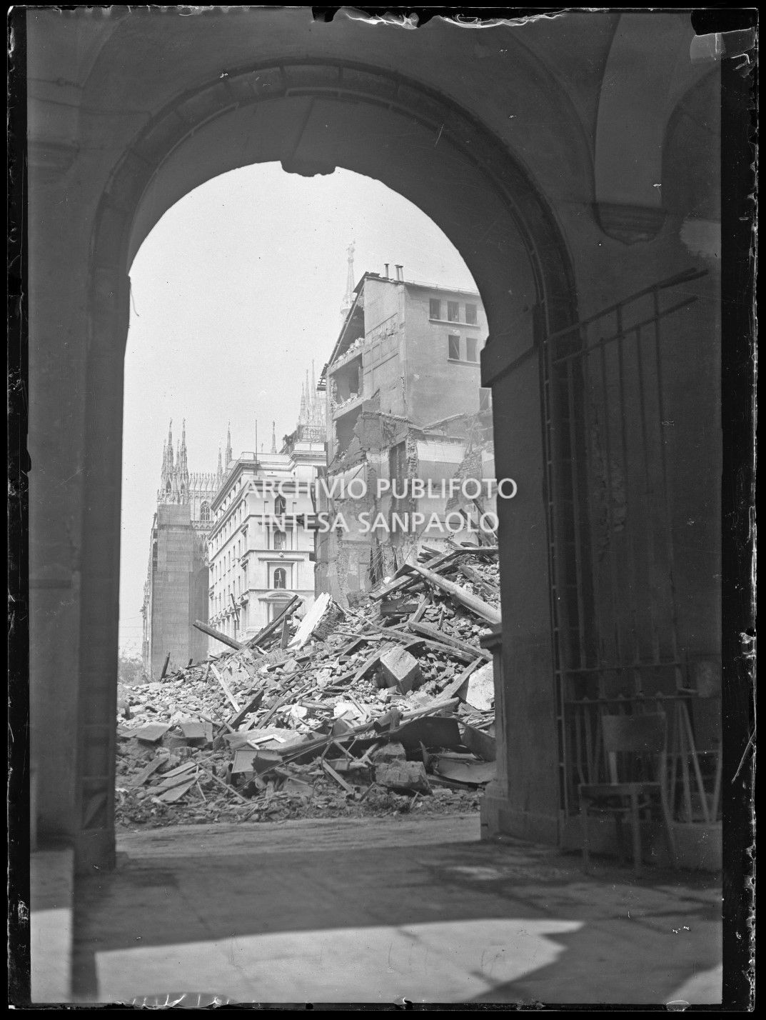 Scorcio del lato nord di piazza Fontana a Milano ingombra delle macerie degli edifici, che affacciano sulla piazza, sventrati dai bombardamenti. Sullo sfondo il Duomo