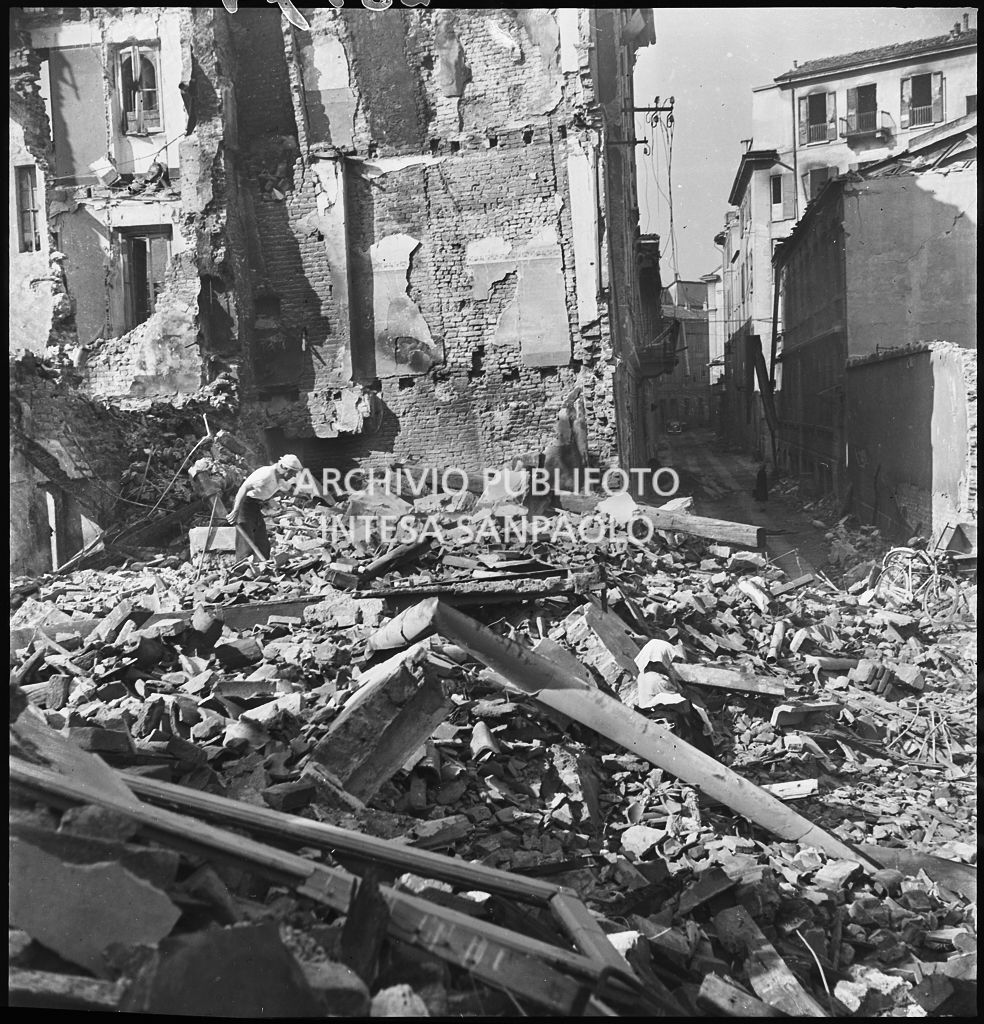Un uomo con una pala tra le macerie degli edifici distrutti dai bombardamenti in via Beno de' Gozzadini (via che oggi non esiste più, collegava corso Italia all'allora corso Roma, oggi corso di Porta Romana)