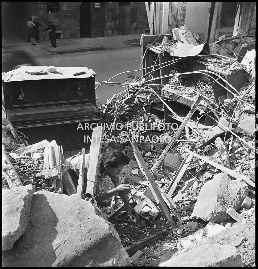 Un pianoforte verticale tra le macerie degli edifici bombardati in via Beno de' Gozzadini (via che oggi non esiste più, collegava corso Italia all'allora corso Roma, oggi corso di Porta Romana)