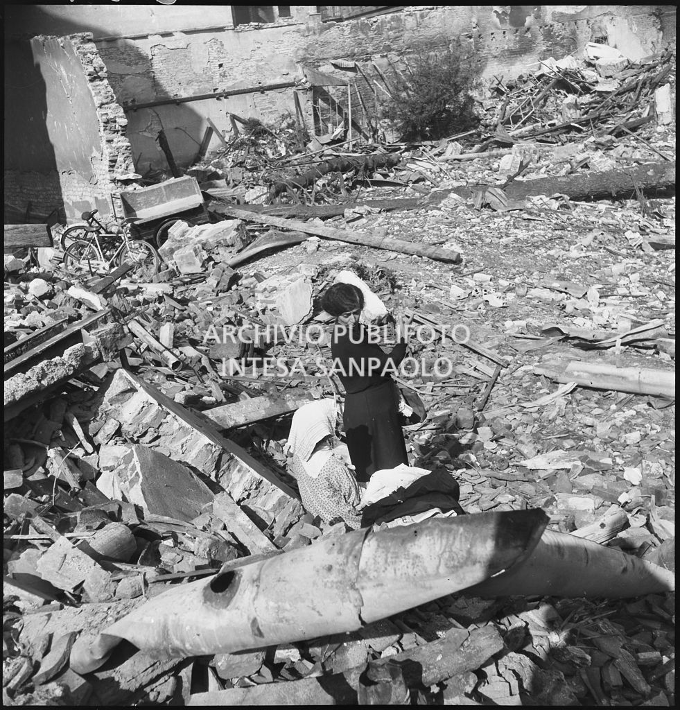 Una donna tra le macerie degli edifici distrutti dai bombardamenti in via Beno de' Gozzadini  (via che oggi non esiste più, collegava corso Italia all'allora corso Roma, oggi corso di Porta Romana)