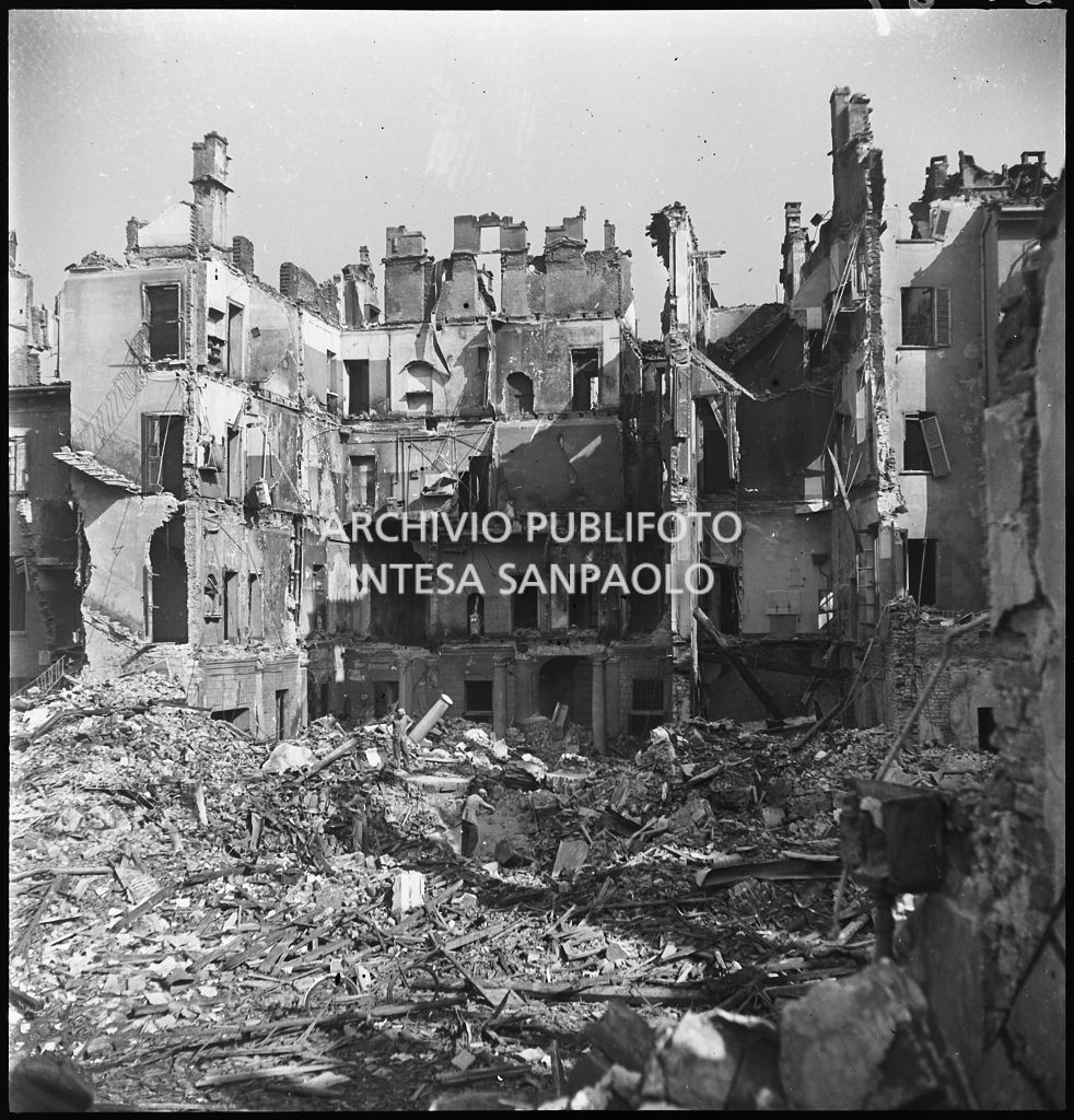 Un uomo tra le macerie degli edifici distrutti dai bombardamenti in via Beno de' Gozzadini  (via che oggi non esiste più, collegava corso Italia all'allora corso Roma, oggi corso di Porta Romana)