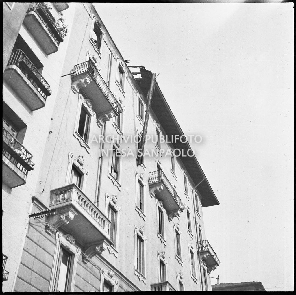 Scorcio dal basso di un edificio danneggiato dai bombardamenti e di una grondaia pericolante