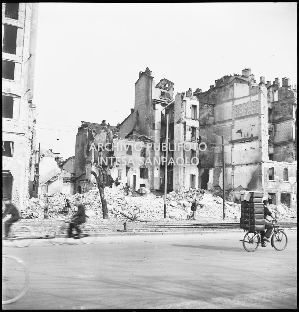 Edifici in via Legnano a Milano distrutti dai bombardamenti. A destra una bicicletta trasporta sette valigie.