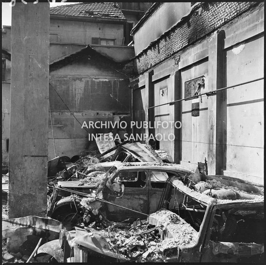 Autorimessa Loreto, ingombra di macerie dei bombardamenti che hanno fatto crollare il tetto e danneggiato le automobili ricoverate