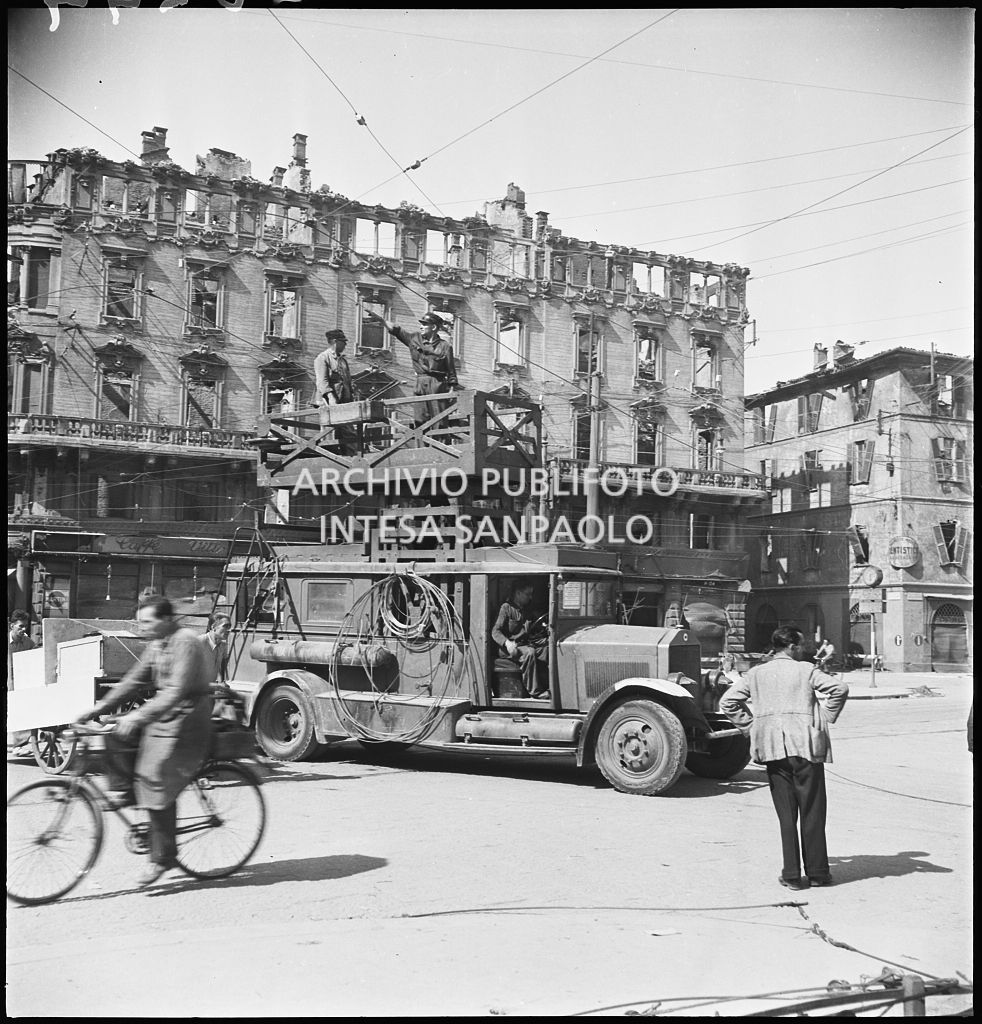 Riparazione delle linee aeree dei tram, danneggiate dai bombardamenti, con l'ausilio di un trabattello in via Cesare Correnti a Milano