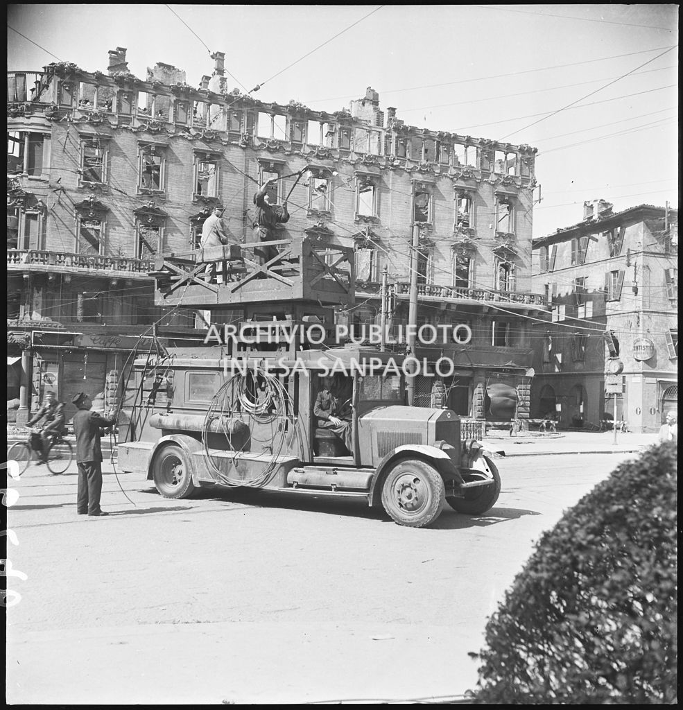 Riparazione delle linee aeree dei tram, danneggiate dai bombardamenti, con l'ausilio di un trabattello in via Cesare Correnti a Milano
