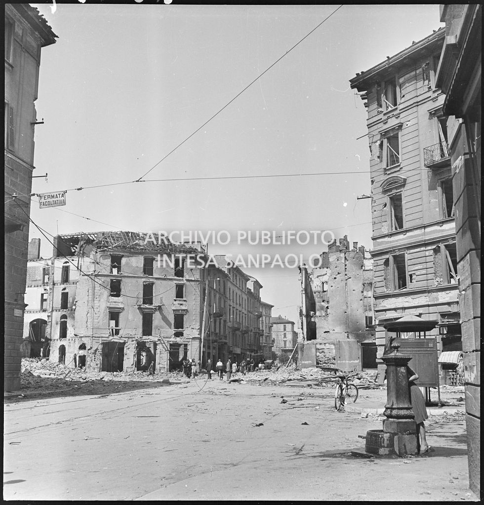 Via Luigi Canonica, a Milano, con gli edifici sventrati dai bombardamenti. Sulla destra una fontanella e un vespasiano