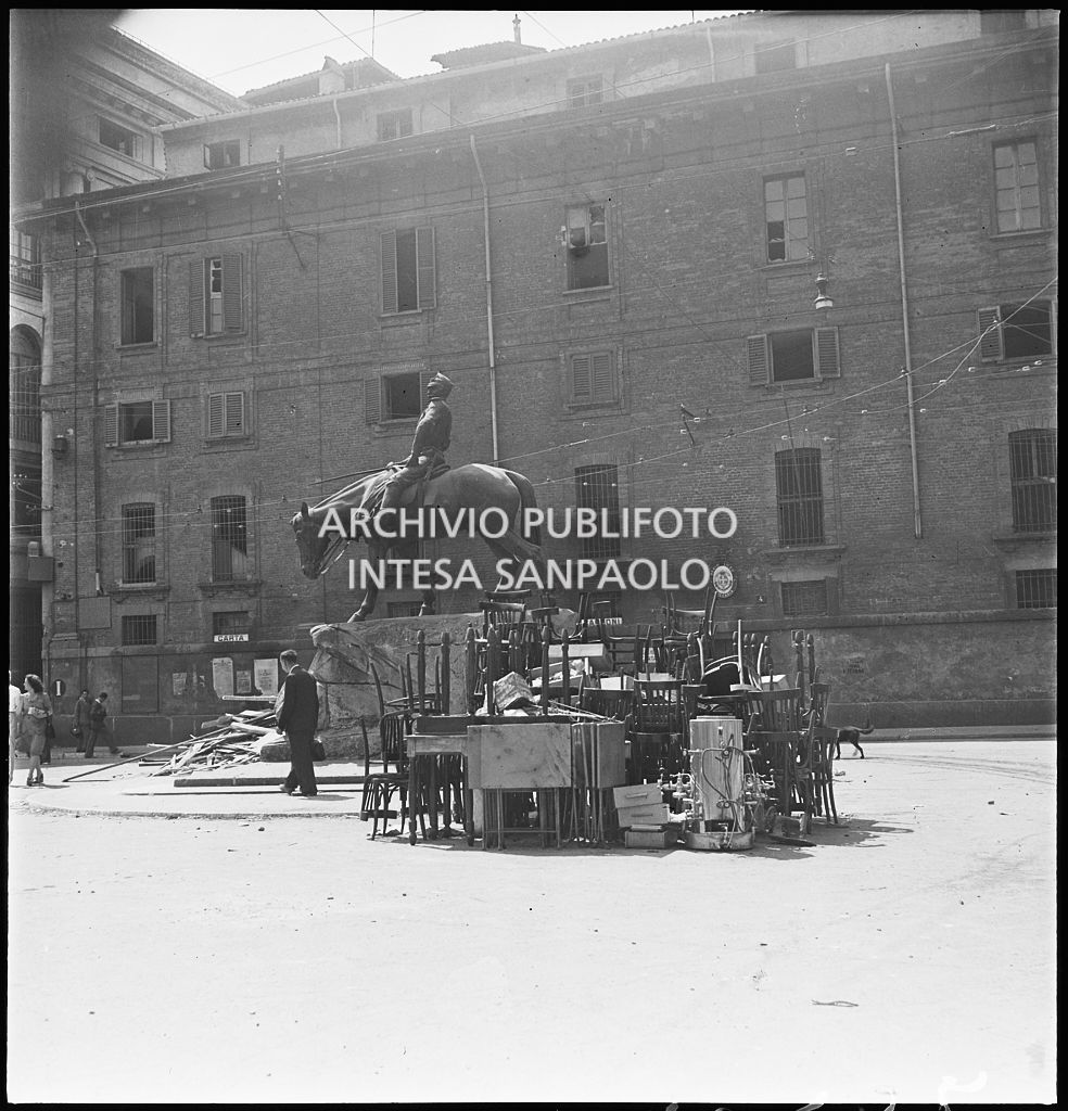 Il monumento a Giuseppe Missori, nell'omonima piazza di Milano, all'indomani dei bombardamenti della città: in primo piano masserizie recuperate dagli edifici bombardati, presumibilmente dal "Regio Liceo Ginnasio Cesare Beccaria", la cui sede è sullo sfondo