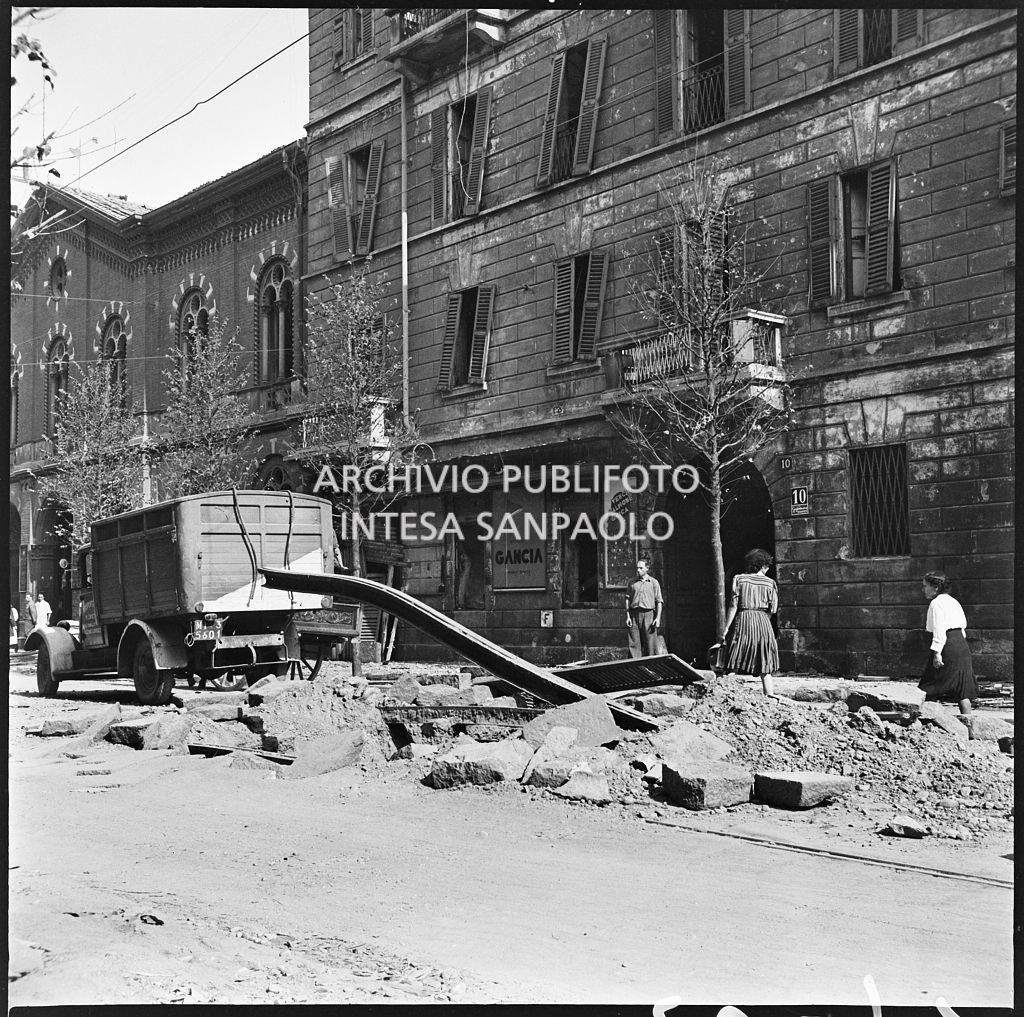 Scorcio di una via di Milano all'indomani dei bombardamenti che hanno divelto i binari del tram e danneggiato gli edifici