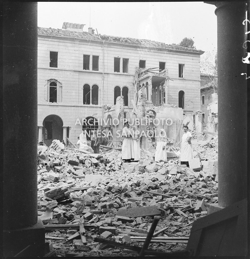 Religiosi in un cortile dell'Ospedale San Giuseppe ingombro delle macerie dei bombardamenti che lo hanno gravemente danneggiato