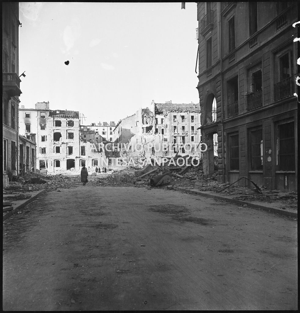 Viale Papiniano con gli edifici bombardati e le macerie addossate ai lati della strada