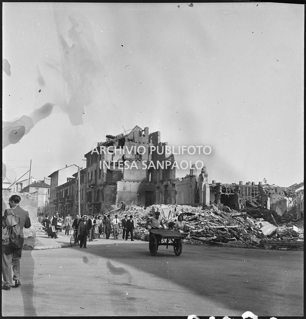 Passanti in via Piero della Francesca dopo i bombardamenti che hanno distrutto gli edifici della via