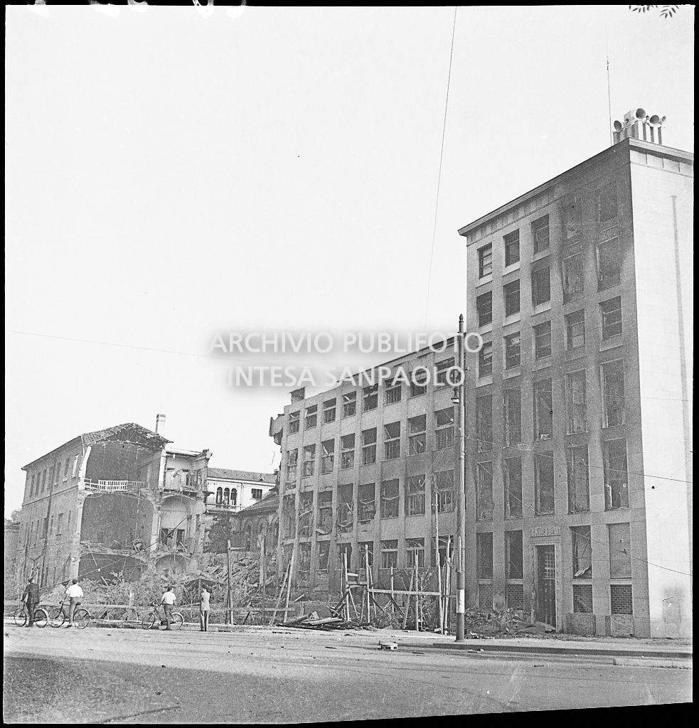 Scorcio del Palazzo del Popolo d'Italia, poi Palazzo dell'Informazione, sul lato di via del Vecchio Politecnico Cavour a Milano, danneggiato dai bombardamenti. Sullo sfondo un edificio sventrato