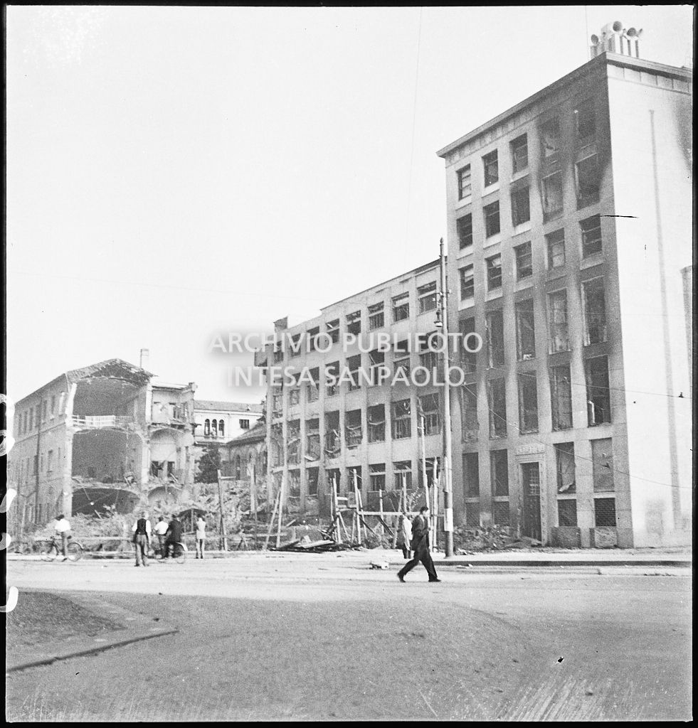 Scorcio del Palazzo del Popolo d'Italia, poi Palazzo dell'Informazione, sul lato di via del Vecchio Politecnico Cavour a Milano, danneggiato dai bombardamenti. Sullo sfondo un edificio sventrato