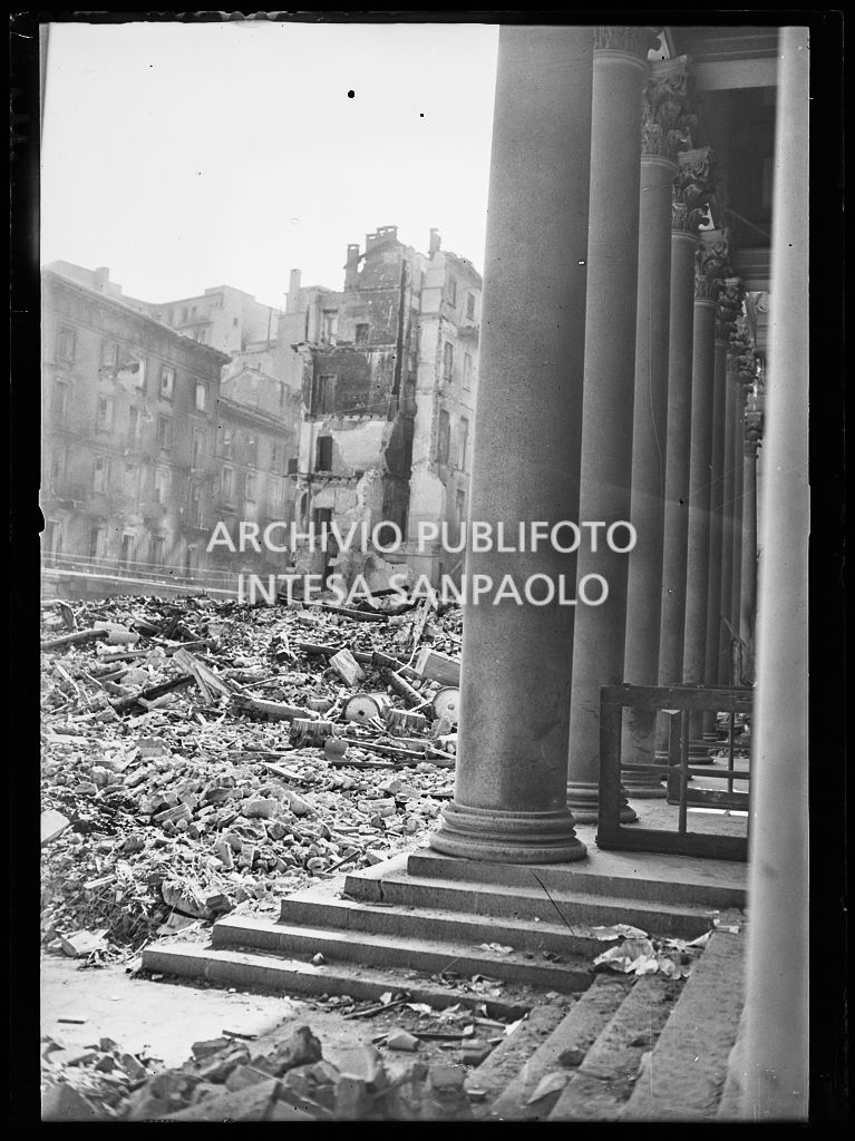 Scorcio di piazza San Carlo a Milano, all'indomani dei bombardamenti, ingombra delle macerie degli edifici e della basilica di San Carlo al Corso gravemente danneggiata durante gli attacchi aerei