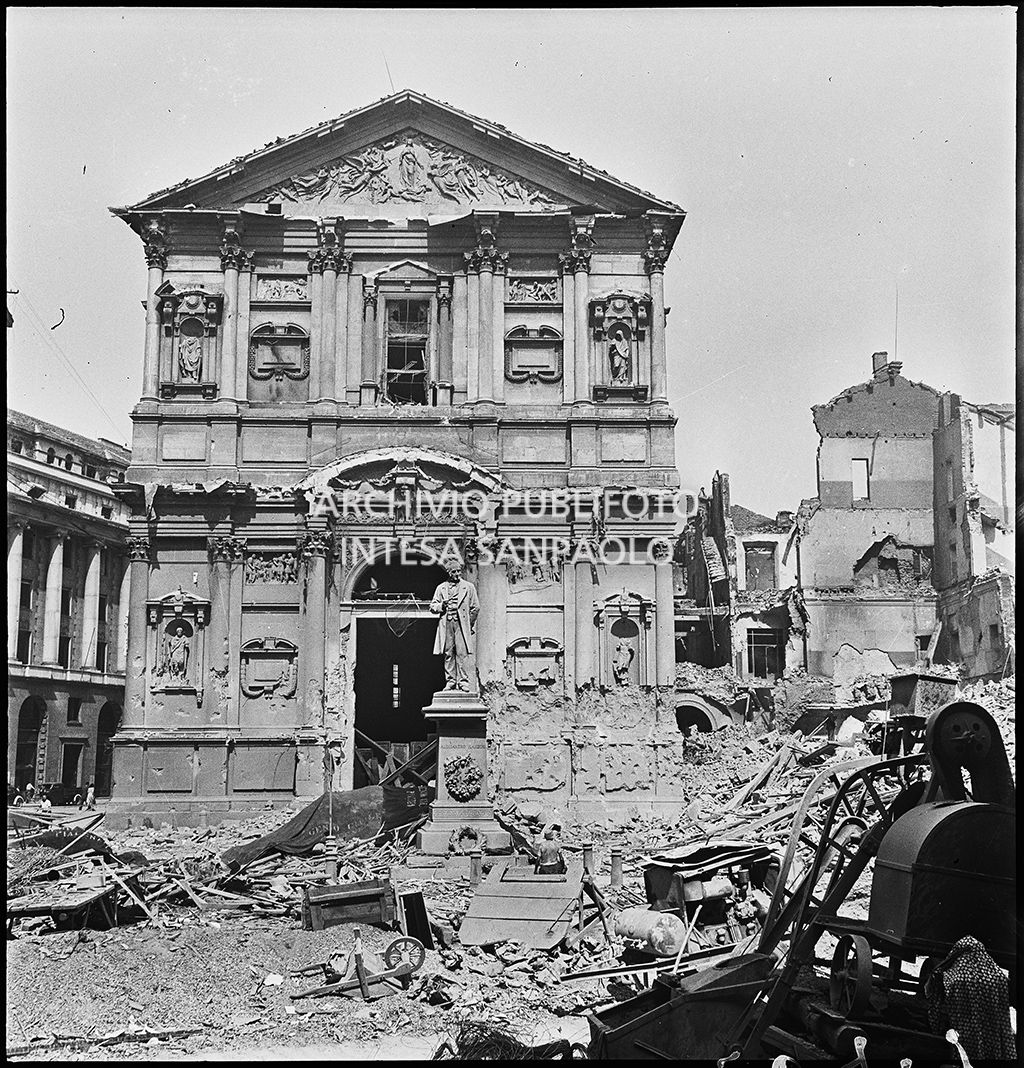 Chiesa di San Fedele, nell'omonima piazza a Milano,  gravemente danneggiata dai bombardamenti; sulla destra l'edificio che ospitava la questura della città, completamente distrutto; in mezzo alla piazza il monumento a Alessandro Manzoni intatto.