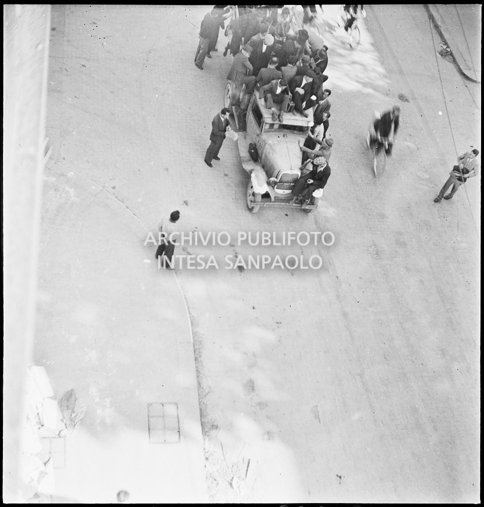 Un autocarro gremito di persone che cercano un passaggio per lasciare la città dopo i bombardamenti di Milano