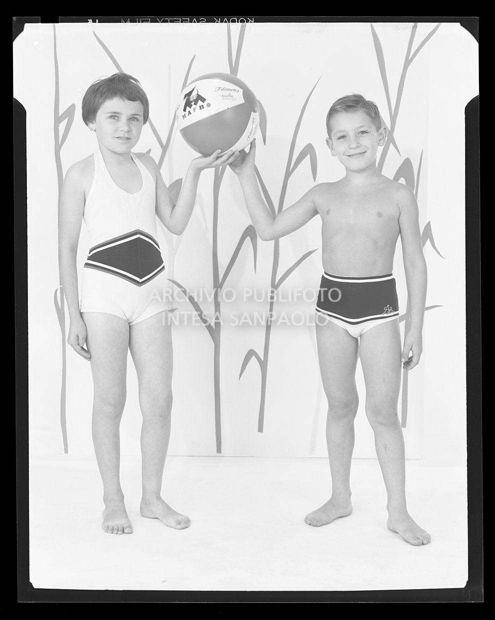 Bambina con costume intero e bambino con costume a pantaloncino con palla con la scritta "Mafbo Filanca"<br>21225