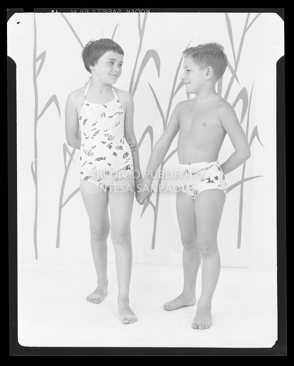 Bambina con costume intero e bambino con costume a pantaloncino con la stessa fantasia marina<br>21230