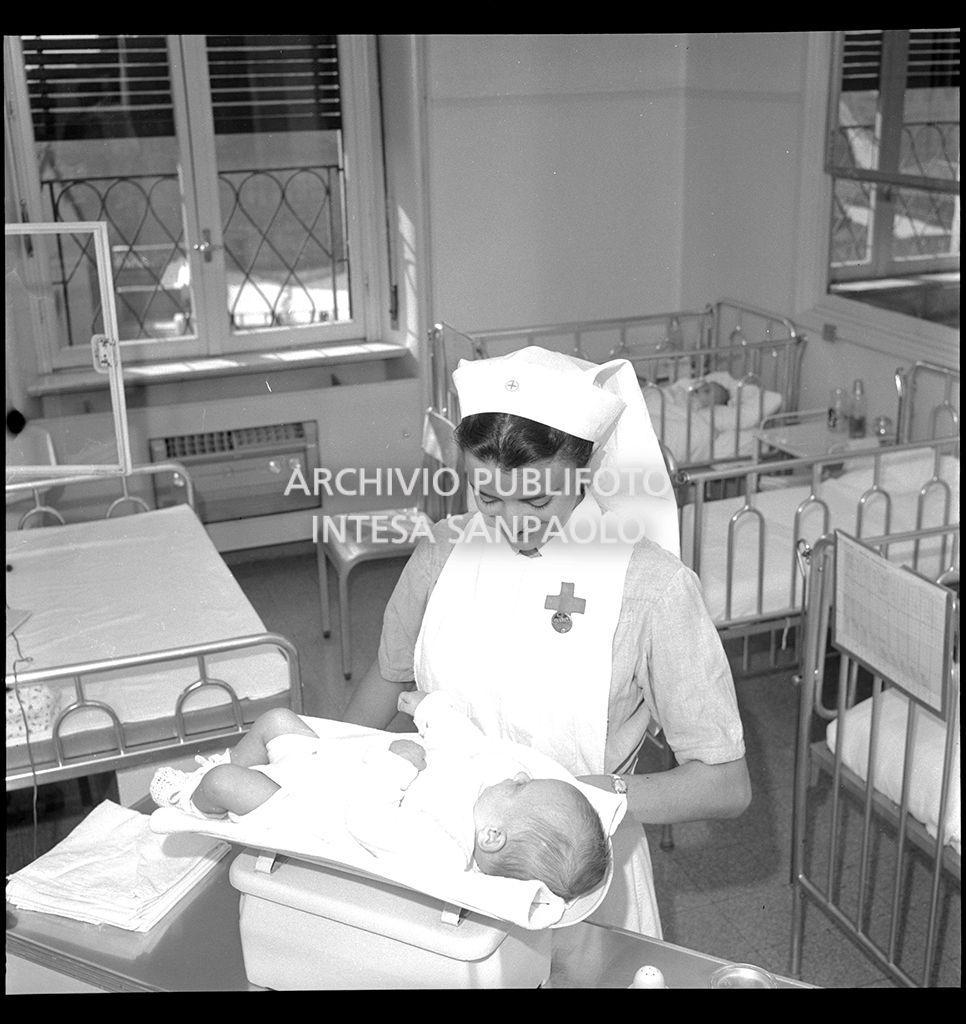 Infermiera nel nido mentre pesa un neonato<br>21242
