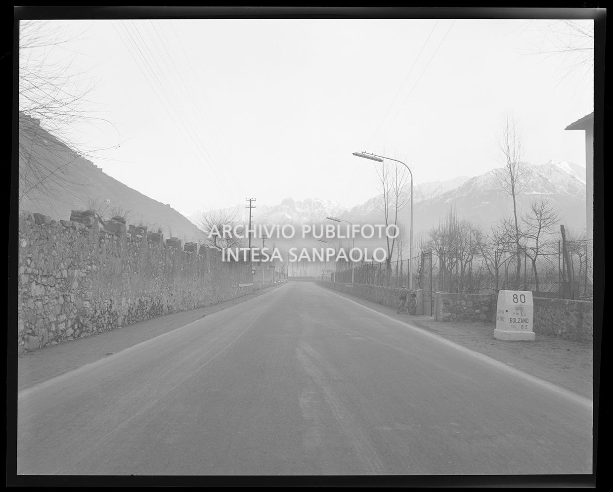 Strada di montagna con una pietra miliare con la scritta: "80 Cogno km 1,5 Bolzano km 165" (uguale allo scatto 25243)<br>25245